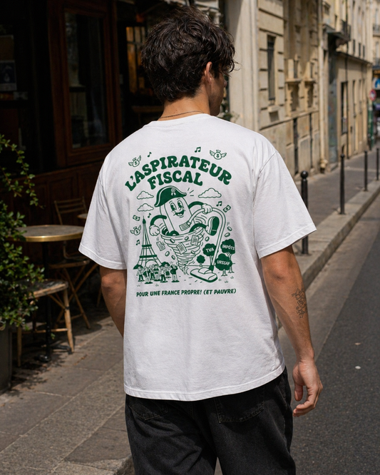 Photographie de dos d'un homme marchant dans une rue pavée de Paris, portant un t-shirt blanc avec une illustration graphique verte. Le dessin représente un personnage de dessin animé en forme d'aspirateur anthropomorphe nommé « L'Aspirateur Fiscal ». Il aspire de l'argent, la Tour Eiffel et des citoyens dans une tornade. On peut lire les inscriptions « TVA », « IMPÔTS » et « URSSAF » sur des buissons, ainsi que le slogan satirique en bas : « POUR UNE FRANCE PROPRE ! (ET PAUVRE)