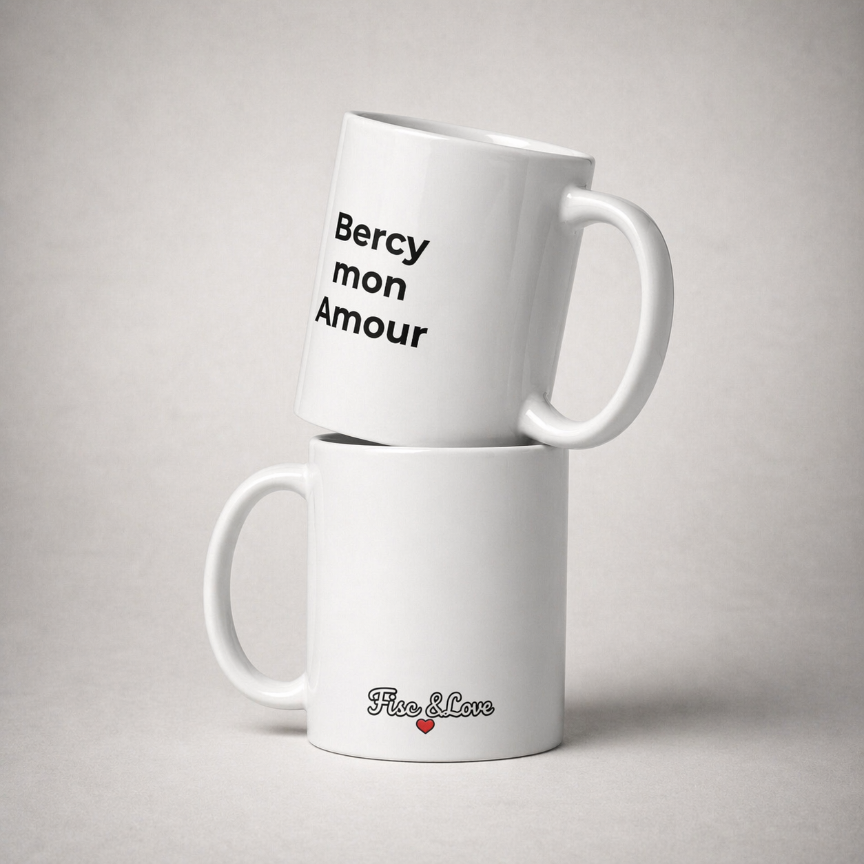 Duo de mugs "Bercy mon Amour" empilés, montrant le slogan noir à l'avant et le logo Fisc & Love avec petit cœur rouge à l'arrière sur céramique blanche